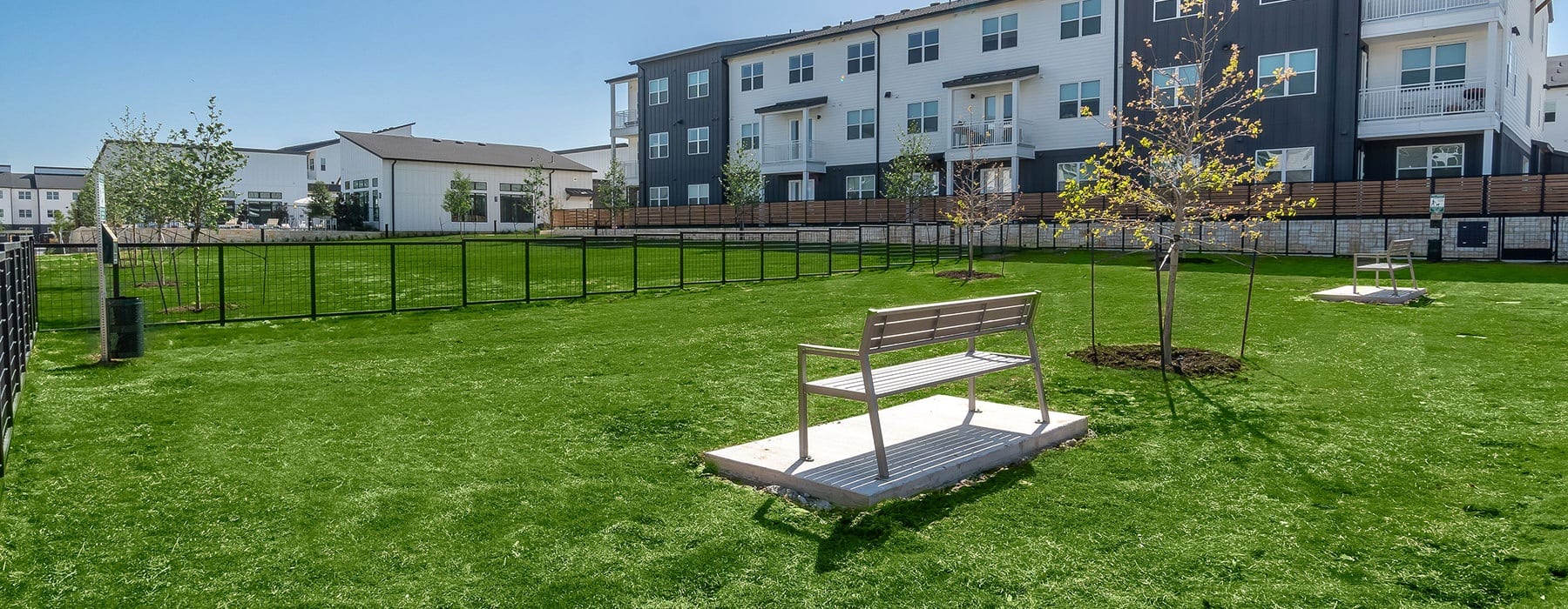 Large open green space with fenced dog park